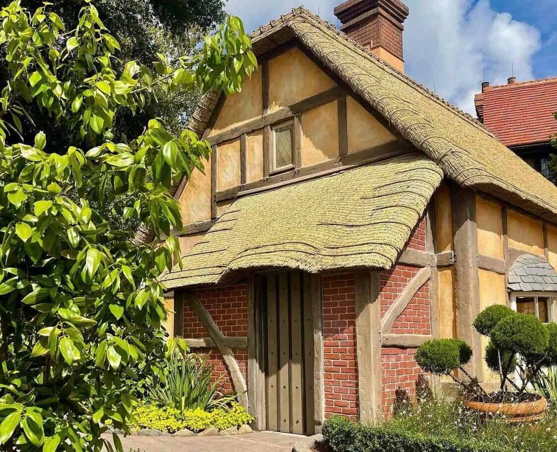 Step into a charming little cottage with a thatched roof, rustic timber beams, and classic brick walls surrounded by a vibrant garden—just like the storybook houses you’ll see at EPCOT’s United Kingdom Pavilion. Discover the magic of British architecture and soak in the pavilion’s timeless charm!.