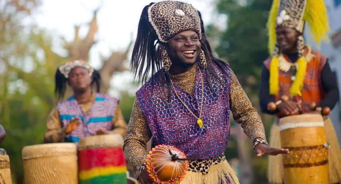 The Tam Tam Drummers bring Harambe’s plaza to life on November 7th as a performer in vibrant traditional costume drums with infectious energy, inviting the crowd to join in the lively celebration.