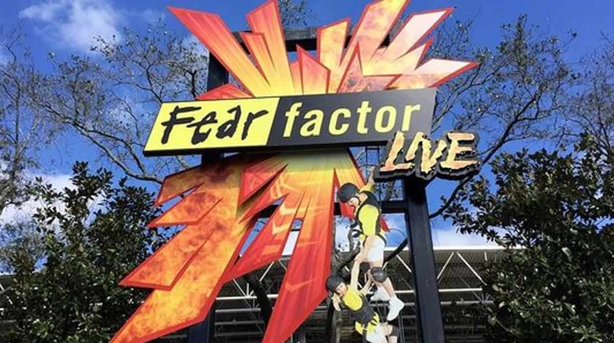 Fear Factor Live entrance at Universal Studios Orlando, featuring its iconic sign with two action mannequins suspended above dramatic red and yellow bursts—a once-thrilling show now bidding farewell to fans.