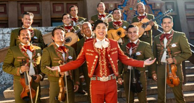 Mariachi Cobre, dressed in colorful traditional costumes, smiles with their instruments on the stone steps at EPCOT’s Mexico Pavilion, bringing the joyful energy of Mexican music to life for guests, reminiscent of the spirit in Disney-Pixar’s Coco.