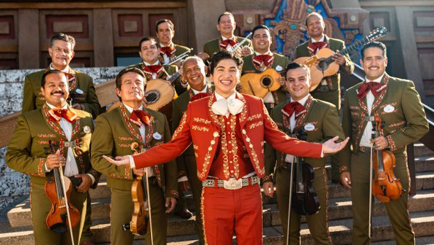 Mariachi Cobre, dressed in colorful traditional costumes, smiles with their instruments on the stone steps at EPCOT’s Mexico Pavilion, bringing the joyful energy of Mexican music to life for guests, reminiscent of the spirit in Disney-Pixar’s Coco.