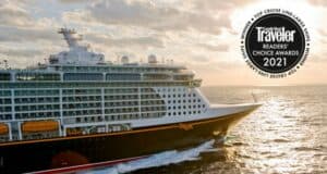 The Disney Cruise Line ship glides through the golden sunset, proudly showcasing its "Condé Nast Traveler Reader’s Choice Awards 2021" badge—a magical voyage celebrating another unforgettable Disney achievement.