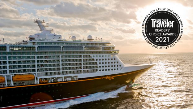 The Disney Cruise Line ship glides through the golden sunset, proudly showcasing its "Condé Nast Traveler Reader’s Choice Awards 2021" badge—a magical voyage celebrating another unforgettable Disney achievement.