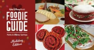 A tempting display of four holiday-themed dishes and desserts sits beside the Disney World Foodie Guide Holiday Edition sign, highlighting the festive flavors and culinary delights awaiting guests during Walt Disney World’s special holiday dining experiences.