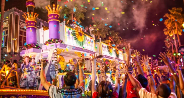A dazzling Mardi Gras parade float lights up the Universal Orlando Resort night, with enthusiastic guests cheering and vibrant confetti filling the air, capturing the electric excitement of the 2022 celebration.