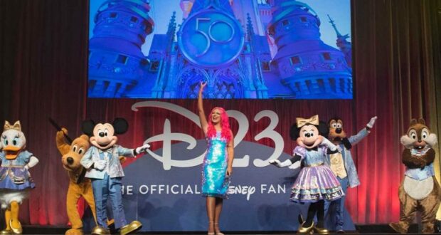 Mickey Mouse, Minnie Mouse, Donald Duck, Goofy, Pluto, and Daisy Duck join a Disney host onstage at Destination D23, with a magical castle backdrop—capturing the spirit of a Sunday Recap for Disney fans.