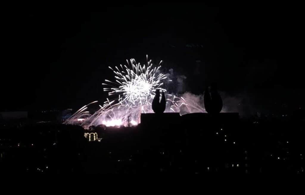 Fireworks illuminate the night sky over the iconic Disney World skyline, with darkened resort buildings below, showcasing the exhilarating spectacle that awaits guests at Walt Disney World and inviting excitement for the magical experience at the new Swan Reserve.