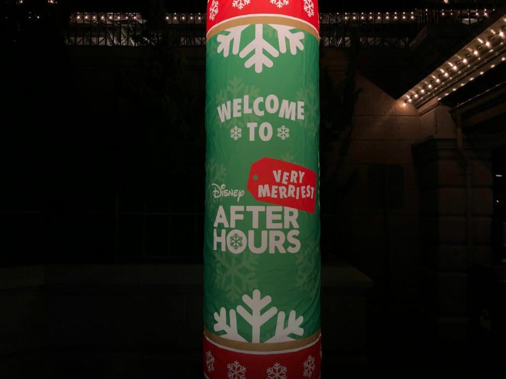 A festive green sign at Magic Kingdom announces "Welcome to Disney Very Merriest After Hours," sparkling with snowflakes and twinkling lights, setting the scene for an enchanting holiday celebration at Walt Disney World.