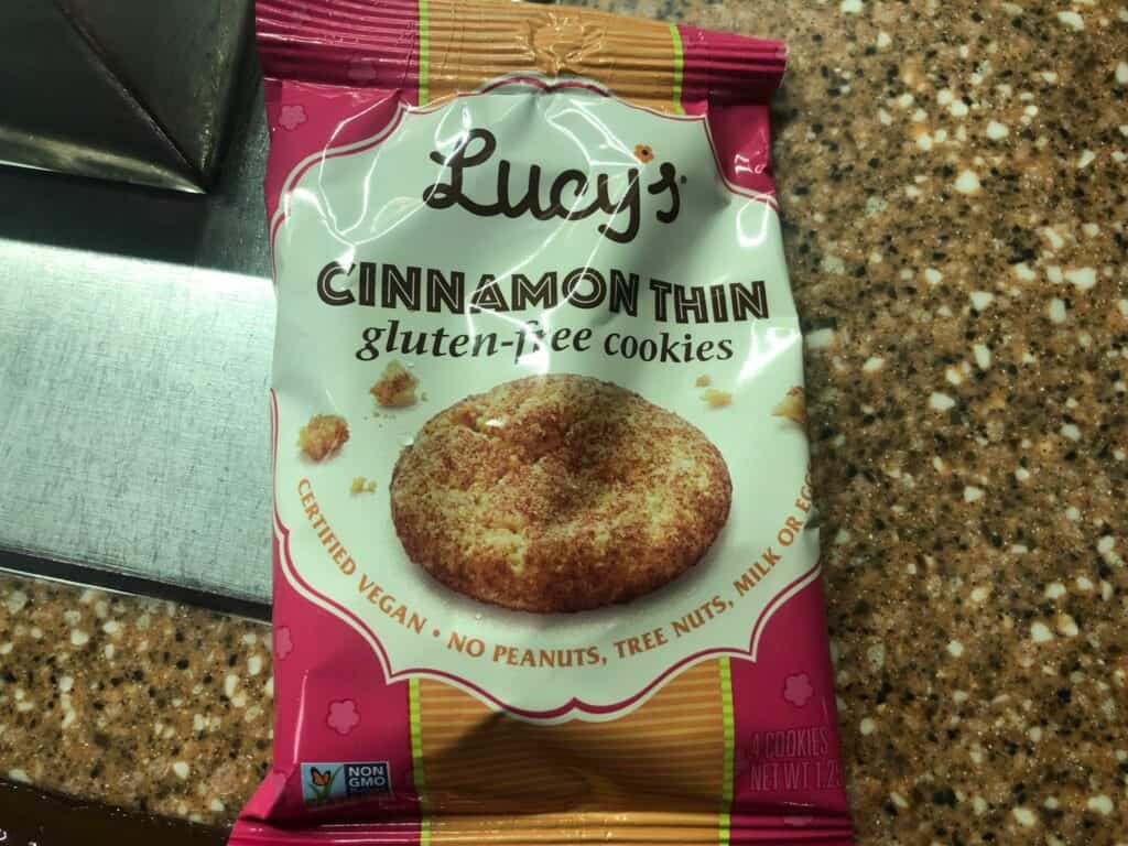 Lucy’s Cinnamon Thin gluten-free cookies on a speckled countertop, ready to be enjoyed as a delicious treat during your visit to the park or gifted alongside your favorite holiday souvenirs from the entertainment resort.