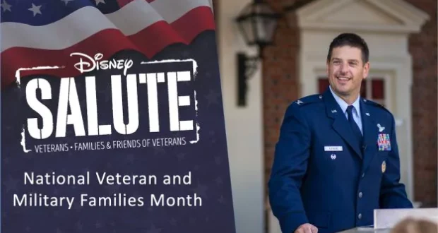 A member of the U.S. military stands at a podium beside a Disney Salute sign during Veterans and Military Families Month festivities, celebrating military heritage at Walt Disney World.