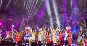 Mickey Mouse, beloved Disney characters, and talented performers dazzle the audience alongside sparkling stars, dancing across a brilliantly illuminated stage adorned with festive Christmas trees and a stunning castle backdrop during the magical Disney Parks Holiday Specials.