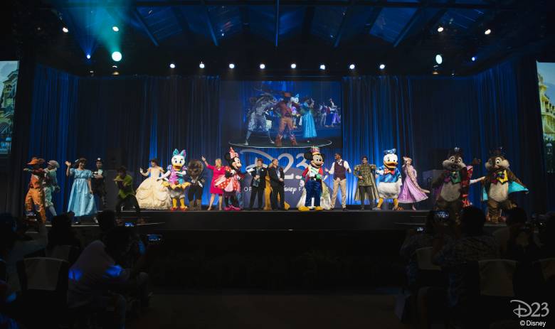 Beloved Disney characters and talented performers gather on stage at Destination D23, delighting fans who eagerly capture the Saturday Recap with their cameras.