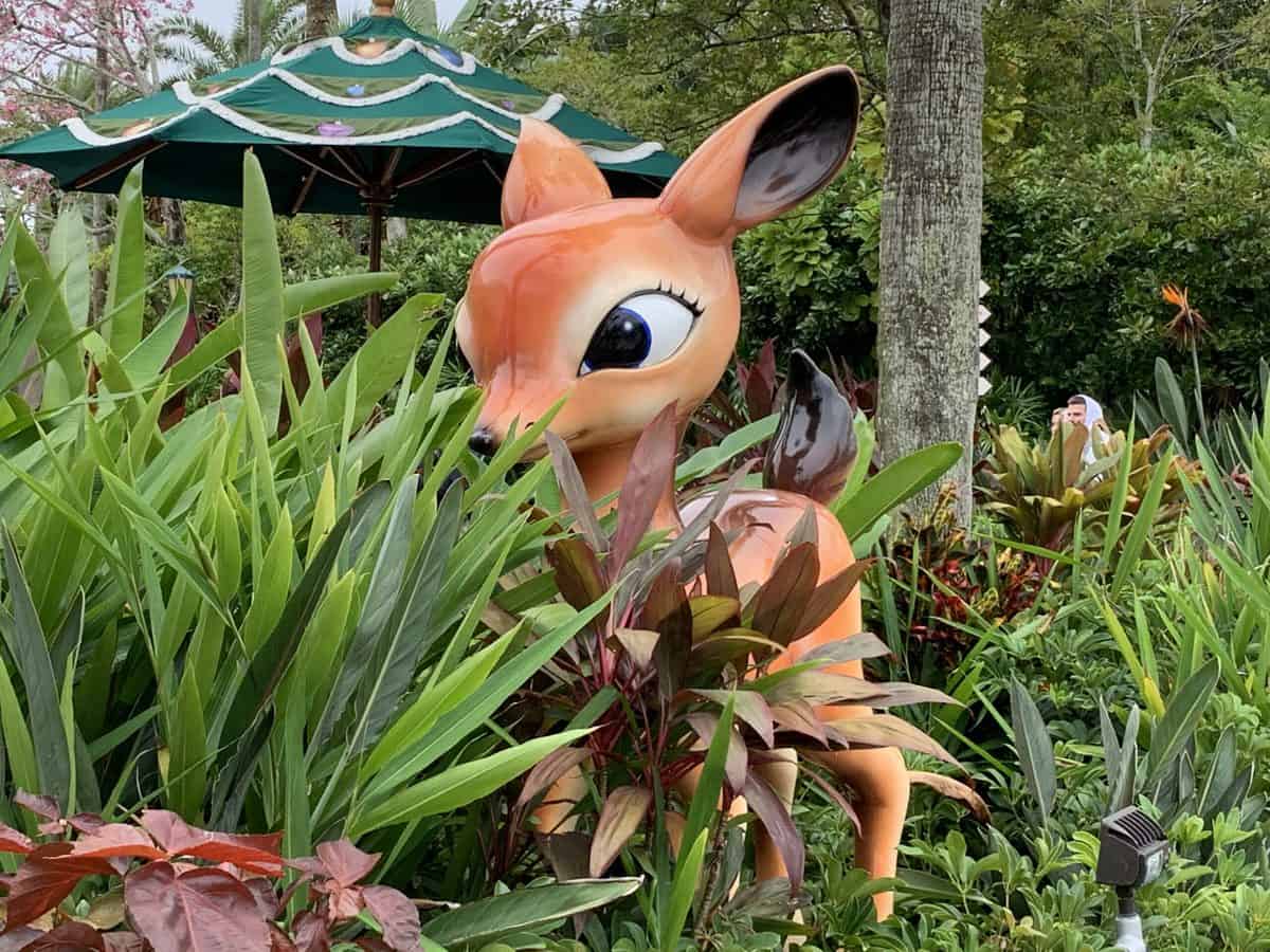 Bambi peeking out from vibrant greenery and garden foliage brings the magic of Disney’s holiday celebrations to life for guests exploring the park.