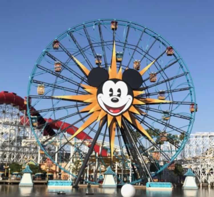 Mickey’s Fun Wheel at Disney California Adventure Park, featuring a giant Mickey Mouse face on its centerpiece, standing tall against a bright blue sky.