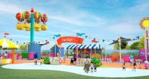 A vibrant amusement park scene featuring a hot air balloon attraction, festive tents, and families enjoying the lively atmosphere beneath a clear blue sky.