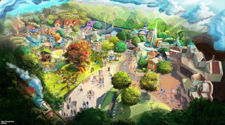 Aerial view of a lively Disney park filled with colorful attractions, winding pathways, lush trees, bustling visitors, and the Disneyland Railroad chugging along the bottom left—an energetic scene buzzes with anticipation ahead of exciting new park announcements.