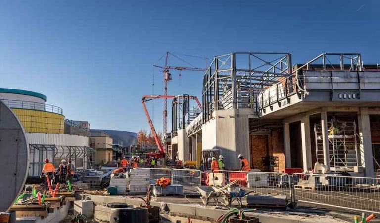Construction crews and heavy equipment working under clear blue skies to build impressive new attractions, reflecting the scale and excitement of expansion projects often unveiled at Disney Parks’ Destination D23 event.