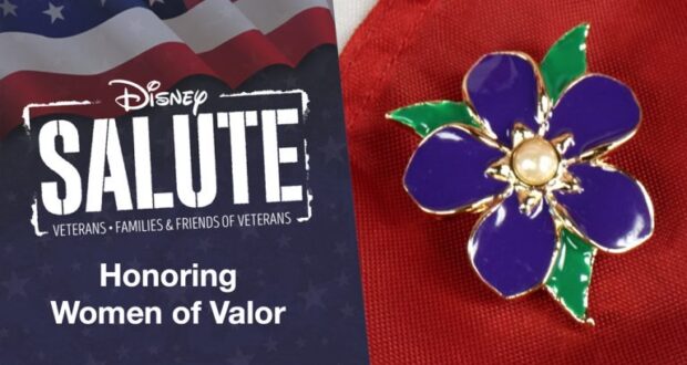 Disney Salute display featuring the message "Honoring Women of Valor" alongside a vibrant purple flower pin, all set against a bold red backdrop.