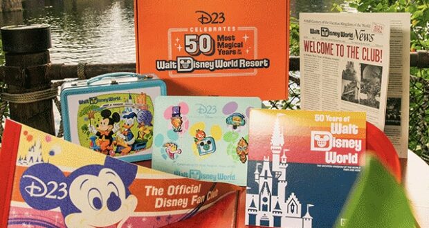 A vibrant display of Disney World’s 50th anniversary collectibles set up along the water, featuring commemorative books and a vintage-style lunchbox, inviting fans to celebrate decades of magic.