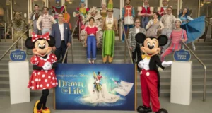 Minnie and Mickey Mouse join talented performers and guests on the steps in front of the vibrant "Drawn to Life" sign, coming together for a memorable Disney photo that celebrates the magic of this spectacular show.