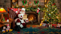 Santa Claus enjoys the cozy glow of a crackling fireplace beside a twinkling Christmas tree at our theme park, carefully checking his list as wrapped presents and festive decor surround him. Make your holiday magical—reserve your spot to meet Santa or join the virtual queue for an unforgettable in-park experience.