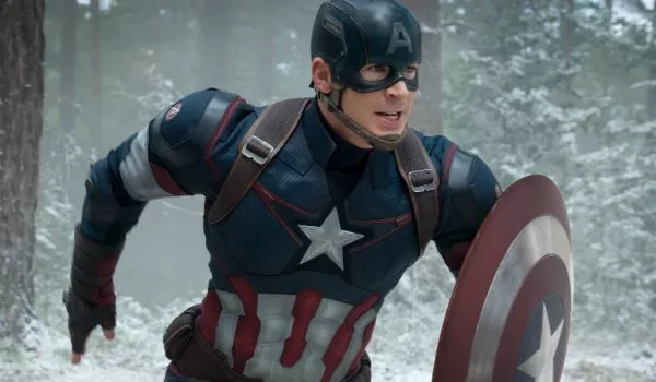 Captain America, as seen at Marvel attractions, dashes through a wintry forest in his iconic blue suit with a star on the chest and signature shield in hand.