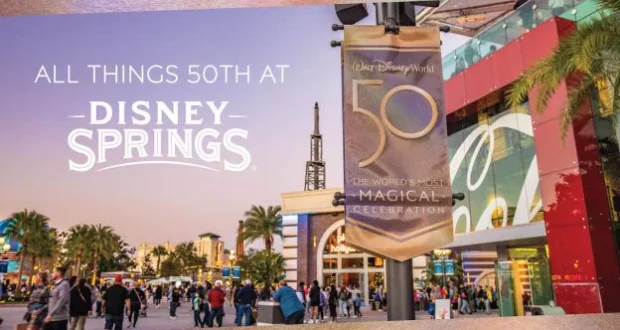 Disney Springs comes alive at sunset, bursting with excitement as fans gather beneath a vibrant "50th: The World's Most Magical Celebration" sign honoring Walt Disney World's milestone anniversary.
