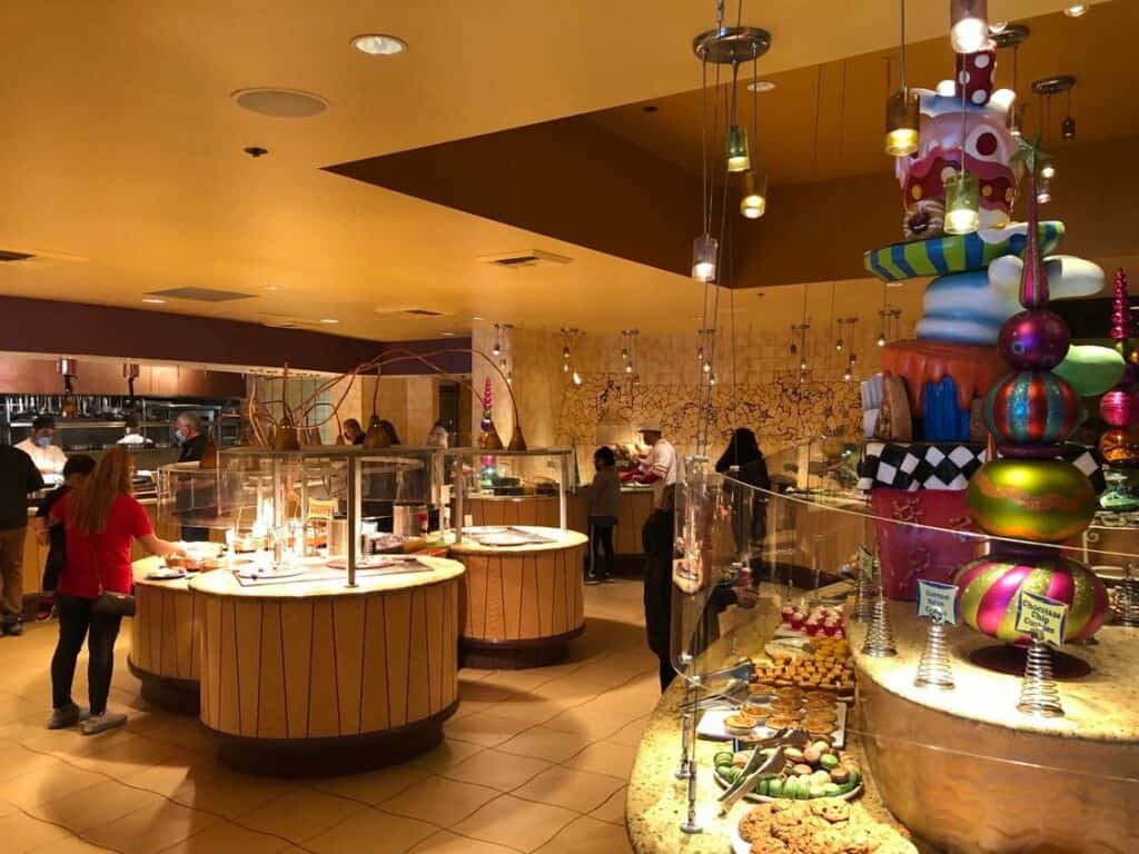 Goofy's Kitchen lights up with a vibrant dessert buffet, where guests help themselves to a tempting array of treats in the energetic, brightly-lit dining hall. The festive atmosphere, bustling with excited visitors and Disney magic, makes this iconic eatery an unforgettable destination for families and fans seeking the ultimate themed dining adventure.