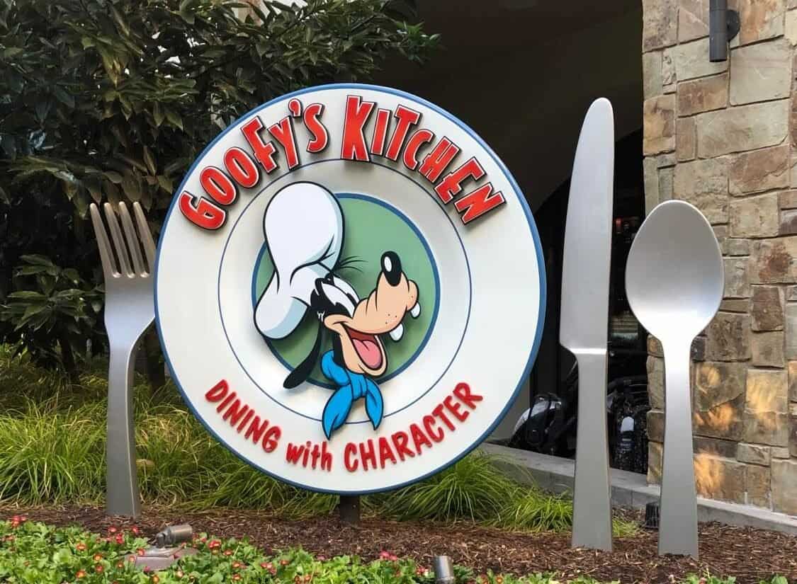 The vibrant Goofy's Kitchen sign features Goofy in his signature chef hat, playfully posed beside oversized fork and spoon props, welcoming guests at Disneyland.