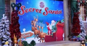 Santa rides his sleigh led by reindeer across a festive "Secret Santa" Disney backdrop, surrounded by sparkling holiday decorations, capturing the magic of Disney’s seasonal celebrations.