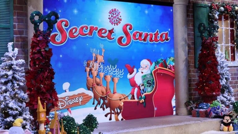 Santa rides his sleigh led by reindeer across a festive "Secret Santa" Disney backdrop, surrounded by sparkling holiday decorations, capturing the magic of Disney’s seasonal celebrations.
