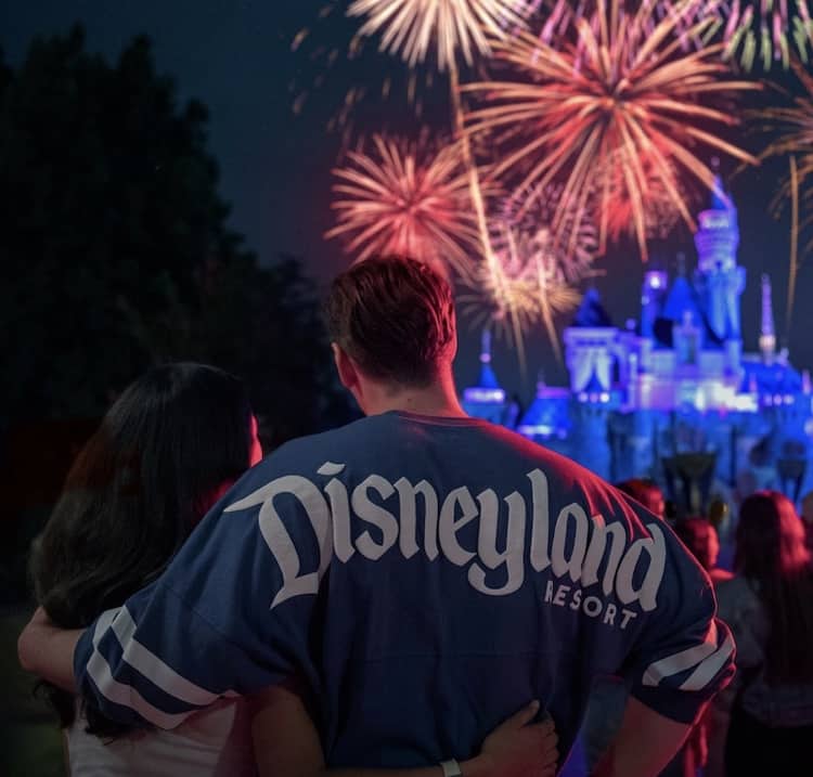 Disneyland After Dark dazzles guests as vibrant fireworks explode above Sleeping Beauty Castle, creating a magical, unforgettable atmosphere for couples and Disney fans enjoying an enchanting night in the park.