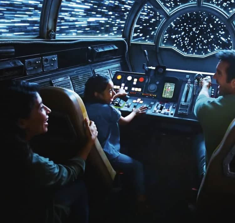 Inside a glowing sci-fi cockpit inspired by Disneyland After Dark, three guests take the controls of a spaceship racing at light speed, their faces beaming with excitement as star trails rush past outside, capturing the electrifying energy of themed nighttime adventures.