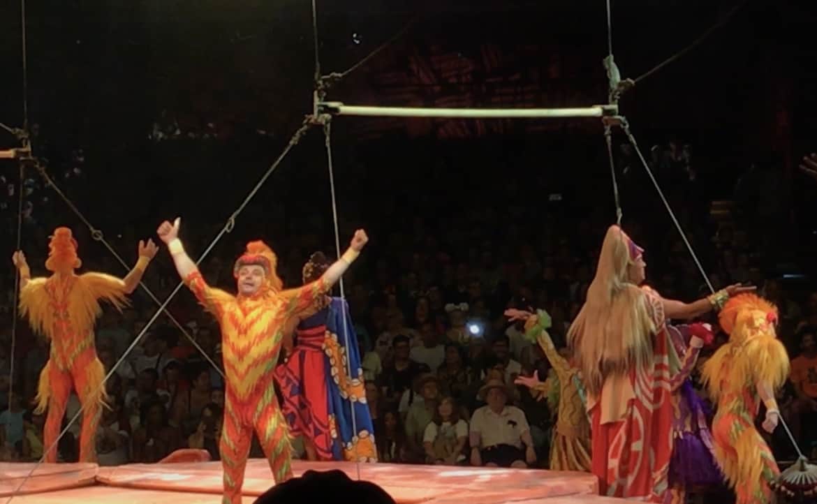 Trapeze artists in vibrant costumes dazzle the crowd at the Grand Circus Arena, thrilling guests with an electrifying performance during the celebrated Return of the Monkeys event.