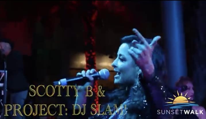 A live performer takes the stage at Sunset Walk, energizing the crowd during a Rocking New Year celebration, with bold "SCOTTY B & PROJECT: DJ SLAM!" and "SUNSET WALK" graphics setting an exciting scene for entertainment fans.
