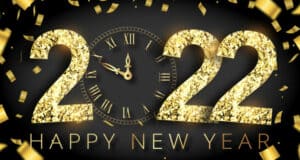 Sparkling gold confetti and a shimmering “2022” sign glimmer above a festive clock, all set against a dramatic black backdrop with bold “Happy New Year” lettering—capturing the excitement and countdown magic of ringing in the new year at your favorite theme park celebration.
