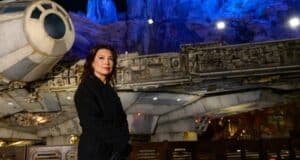 Ming-Na Wen, dressed in black, poses in front of a Star Wars spaceship set with dramatic blue-lit rocky cliffs behind her, capturing the cinematic magic of Disneyland's Galaxy’s Edge.