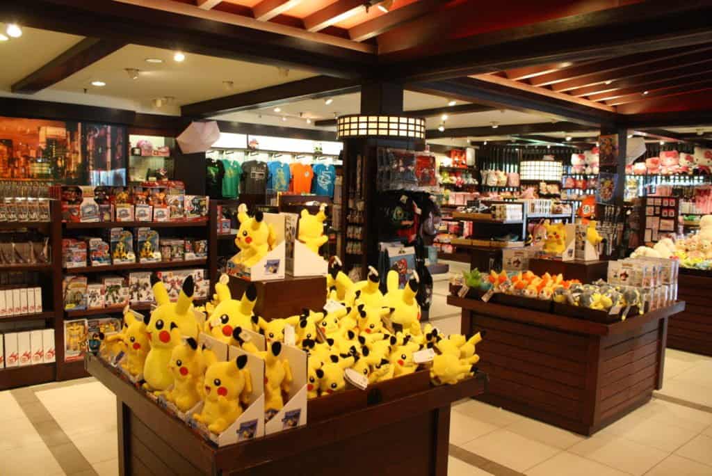 Pikachu plush toys and a variety of Pokémon merchandise fill the shelves and bins inside the lively Pokémon Center at EPCOT’s World Showcase, offering fans an immersive shopping experience in Walt Disney World.