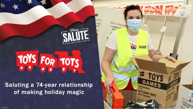 A Disney VoluntEAR wearing a mask carefully packs toys into boxes for Toys for Tots, with the Disney Salute sign in the background showcasing the team's commitment to bringing magic and joy to families in need during the holiday season.