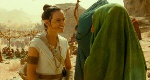 Princess Leia smiles at someone dressed as Boba Fett in Star Wars: Galaxy’s Edge, with other guests exploring the marketplace.