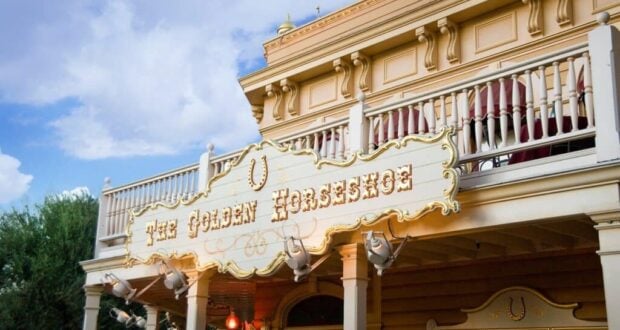 The Golden Horseshoe saloon at Disneyland showcases its ornate sign and iconic upper balcony beneath a partly cloudy sky, captivating guests with its classic Western flair. The lively atmosphere outside this Frontierland favorite continues to draw fans, even as occasional news of security events elsewhere in the park serves as a reminder of Disney’s ongoing commitment to guest safety.