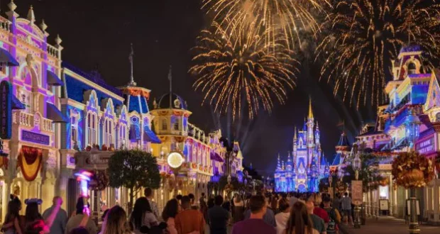 Guests marvel at fireworks bursting above Cinderella Castle and the dazzlingly lit Main Street, U.S.A. at Walt Disney World, capturing the magic of a Disney Enchantment nighttime spectacular with vivid colors and whimsical energy inspired by Eric Goldberg's iconic animation style.
