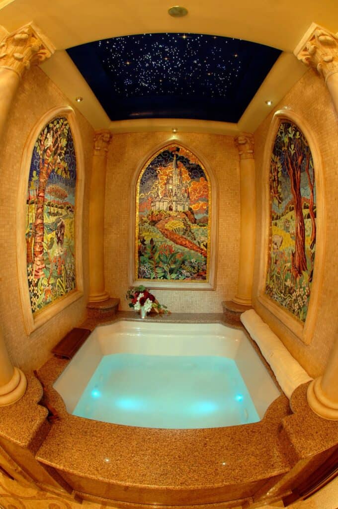 Spa tub with glowing, magical water inspired by Disney’s Cinderella Castle Suite, surrounded by ornate mural walls and a ceiling of sparkling starlight, recreating the fairytale atmosphere found in an immersive Disney resort experience.