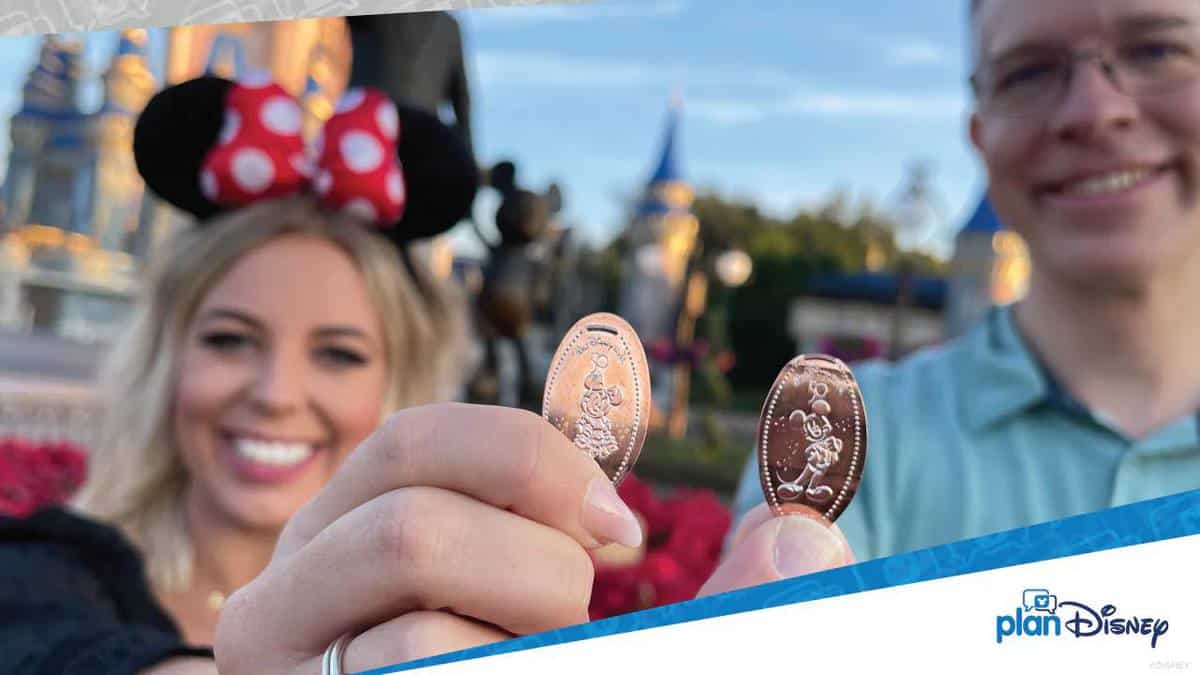 Guests beam with excitement at Walt Disney World, holding up their collectible pressed pennies in front of Cinderella Castle and iconic Minnie Mouse ears as the park celebrates its magical 50th anniversary.