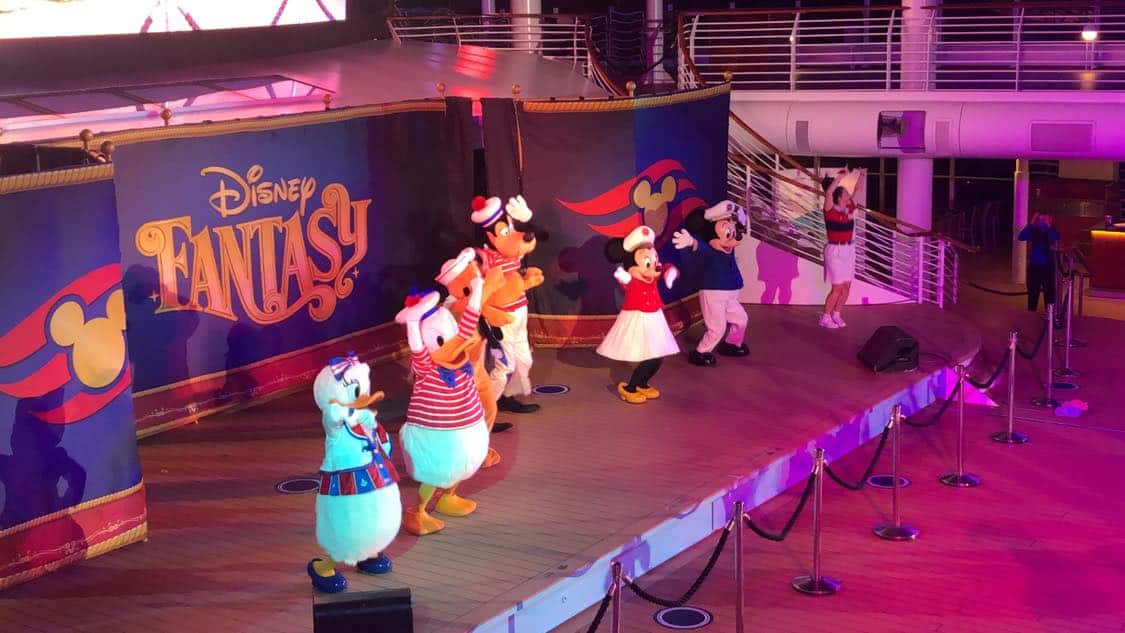 Beloved Disney characters appear live on stage in vibrant costumes aboard the Disney Fantasy cruise ship, creating an unforgettable entertainment experience reminiscent of a Broadway-style show at sea, as highlighted in "My Disney Cruise Line Experience During Covid Part 3: Characters.