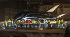Crew members in safety gear gather in front of a sleek Avengers-themed vehicle on a nighttime platform at Disneyland Paris, as new details emerge about the highly anticipated Avengers Campus opening next summer.