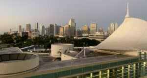 Miami skyline at dusk featuring dazzling skyscrapers and a tent-like amphitheater ready for live entertainment, setting the stage for an exciting night in the city’s vibrant event district.