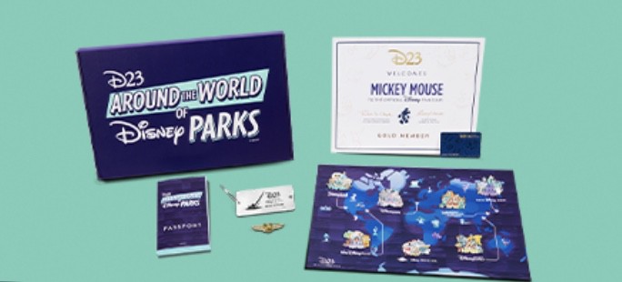 A D23 Disney Parks member kit displayed on a teal background, featuring exclusive collectibles like a commemorative pin, themed passport, collectible card, special edition map, certificate of membership, and booklet celebrating Disney park experiences.