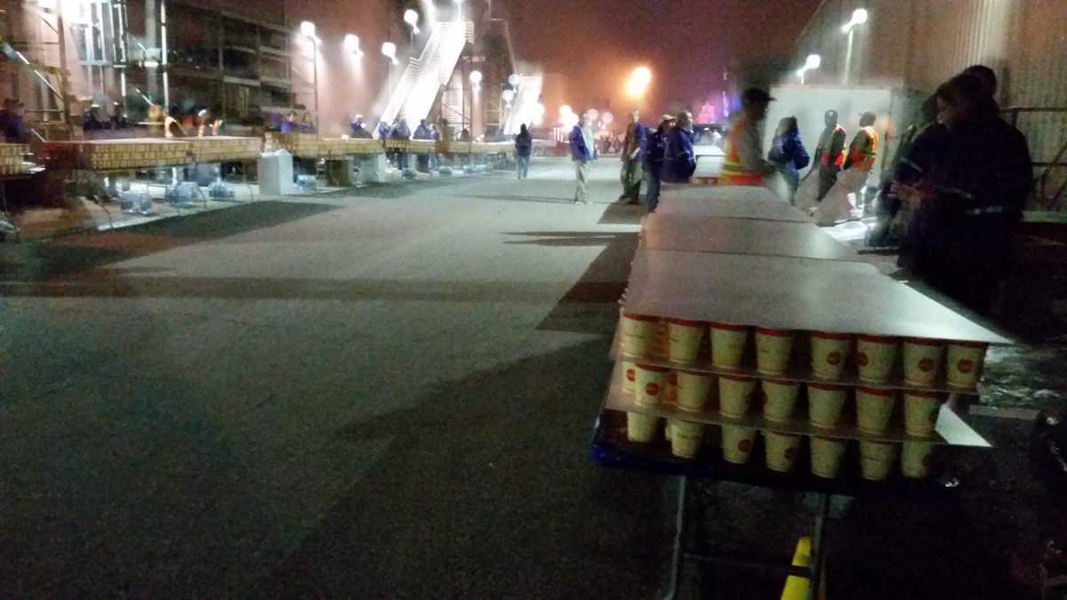 Long tables lined with rows of water-filled paper cups glow under nighttime lights, set and ready for the eager participants of a runDisney Weekend race—capturing the festive spirit and anticipation that fills Walt Disney World during these special marathon events.