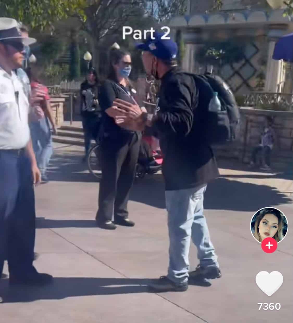 Cast Member in a blue hat engaged in animated conversation with two guests on a Disney park walkway, other visitors strolling by; headline over the scene reads, "Part 2: Here We Go Again—Another Screaming Match at the Happiest Place on Earth.
